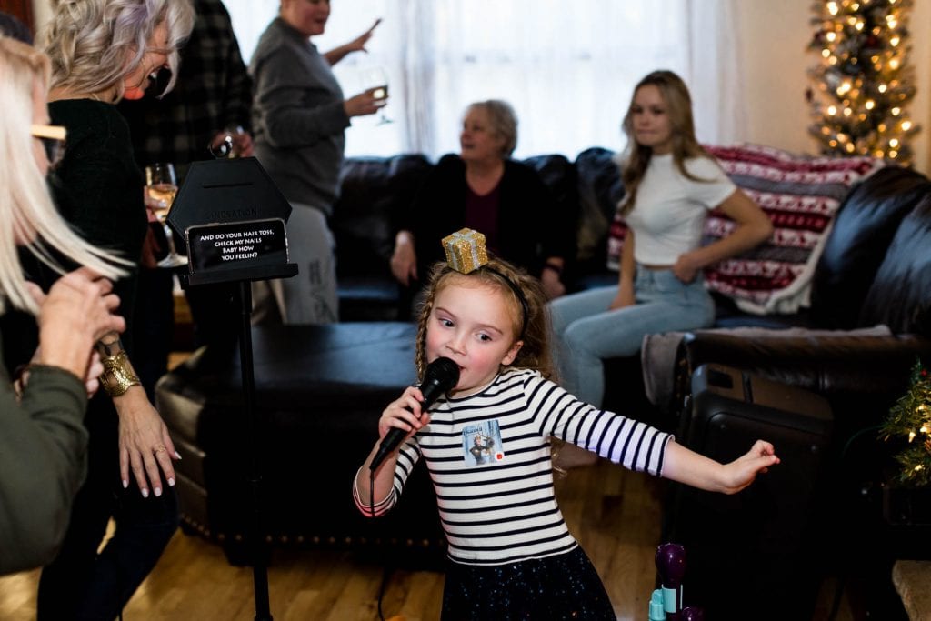 A family singing karaoke together in a living room